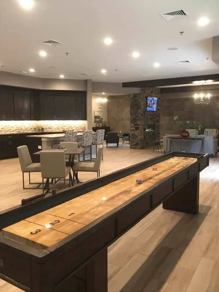Clubhouse great room with a stacked-stone fireplace and warm transitional furnishings.